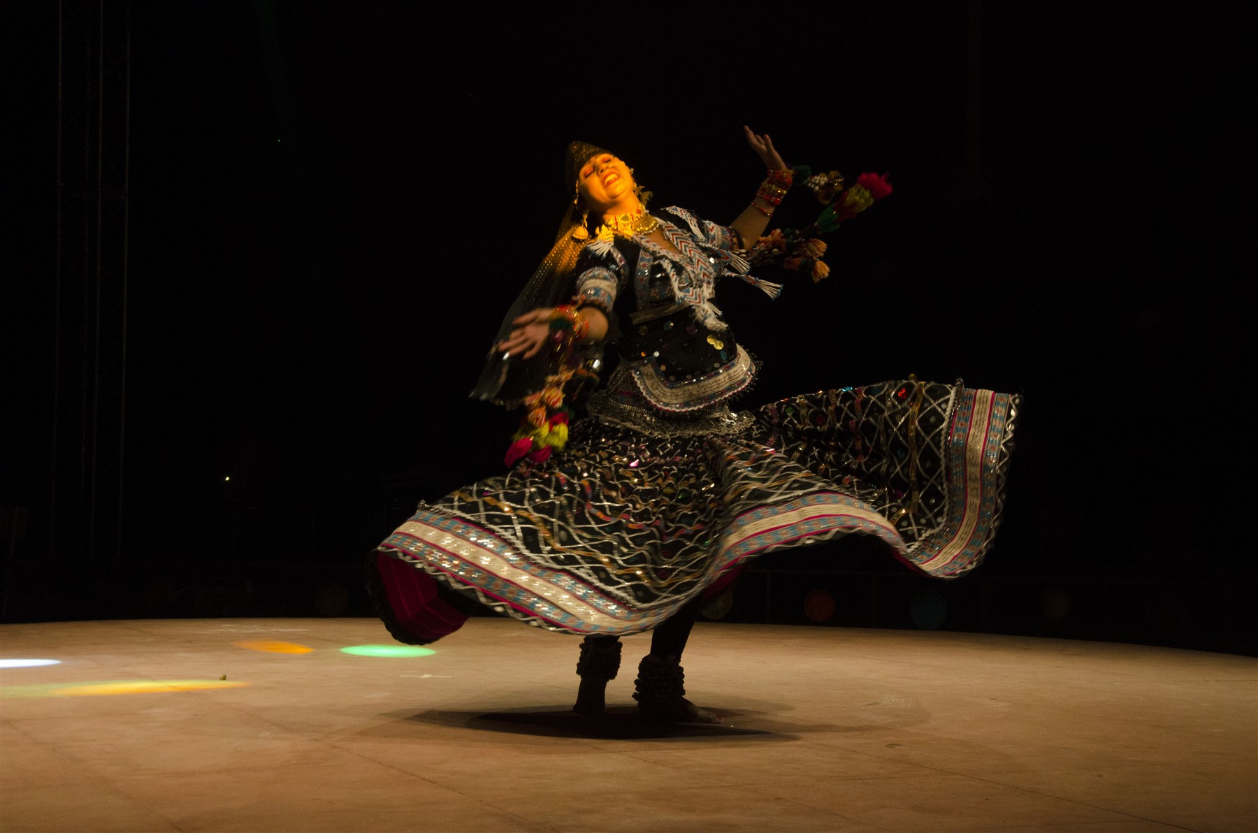 A Kalbelia dancer twirling in a decorated black skirt at Jaipur’s Lokrang festival